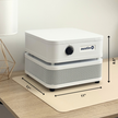 White air purifier with dimensions on a wooden surface